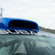 close-up shot of the roof of a blue subaru 2.5rs. the car has subaru written across the top of the windshield, with a large rally-style scoop on the roof meant to draw fresh air into the cabin